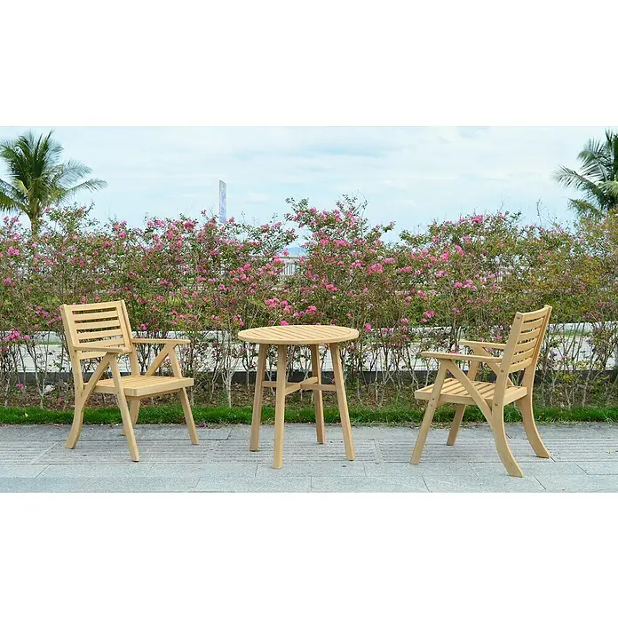 Sunfun Conjunto de muebles de balcón Siena - 3 pzs., Madera de acacia, Marrón - Una mesa de madera con dos sillas al aire libre frente a un arbusto florido. Los muebles irradian un ambiente natural y acogedor.