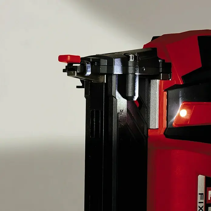 Einhell Professional PXC 18V Grapadora de batería FIXETTO 18/38 S - 18 V, Sin batería - Primer plano de una clavadora roja con cargador negro y gatillo rojo. Ideal para proyectos de construcción y renovación.