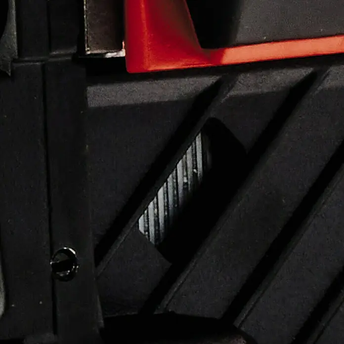 Einhell Professional PXC 18V Grapadora de batería FIXETTO 18/38 S - 18 V, Sin batería - Vista detallada de un producto negro y rojo, posiblemente una herramienta o un aparato con superficies texturizadas.