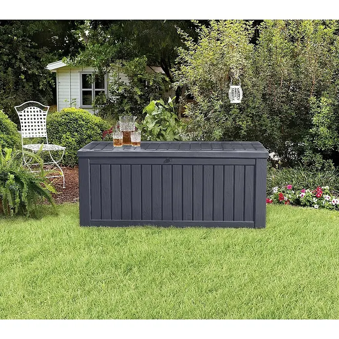 Keter Gartenbox Rockwood - 570 l, Kunststoff - Ein grauer Gartentruhe aus Holz steht auf einem Rasen mit Getränken obenauf.