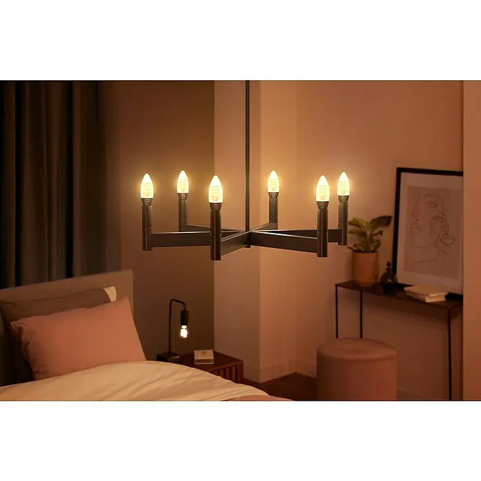 Philips Hue LED-Lampe Filament Classic White Ambiance - E14, 350 lm, Einstellbare Farbtemperatur, 2 Stk. - Ein modernes Zimmer mit einem eleganten schwarzen Kronleuchter mit warm leuchtenden Kerzenlampen als Blickfang.