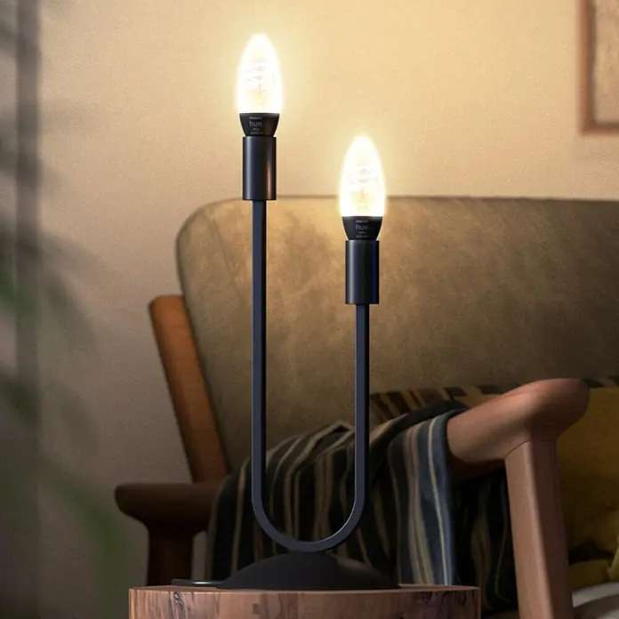 Philips Hue LED-Lampe Filament Classic White Ambiance - E14, 350 lm, Einstellbare Farbtemperatur, 1 Stk. - Ein moderner schwarzer Kerzenleuchter mit zwei LED-Lampen, der eine gemütliche Atmosphäre schafft. Perfekt für jeden Raum.