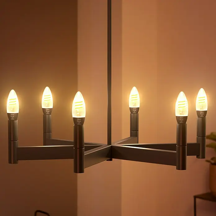 Philips Hue LED-Lampe Filament Classic White Ambiance - E14, 350 lm, Einstellbare Farbtemperatur, 2 Stk. - Nahaufnahme einer modernen schwarzen Deckenleuchte mit sechs LED-Lampen, die ein warmes Licht ausstrahlen, perfekt für eine stilvolle Atmosphäre.