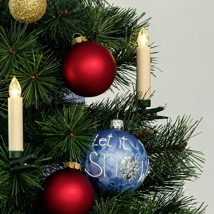 Velas de Navidad LED - 110 mm, Marfil, Color de luz: Blanco cálido, Número de bombillas: 30 ud., IP20 - Árbol de Navidad adornado con adornos rojos, dorados y azules, junto con velas que crean un ambiente festivo.