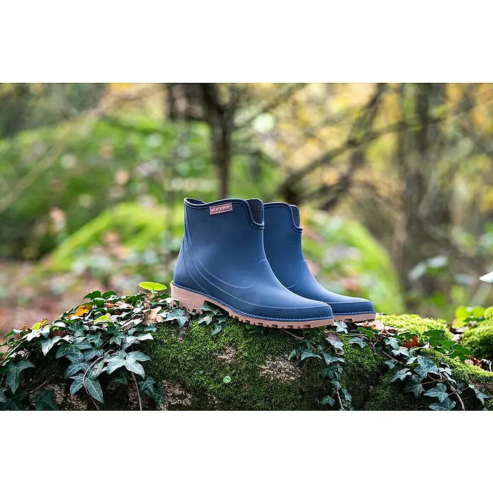 Black Fox Stiefelette PrestonSchuhgröße: 42, Blau - Ein Paar blaue Blackfox Gummistiefel stehen auf einem moosbedeckten Baumstumpf. Ideale Schuhe für Spaziergänge im Wald bei Regenwetter!
