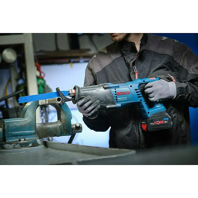 Bosch Professional AMPShare 18V Akku-Säbelsäge GSA 18 V-LI - 18 V, Ohne Akku, Leerlaufhubzahl: 0 /min - 2.700 /min - Ein Handwerker bedient eine Bosch GSA 18 V-LI Professional Säbelsäge, um ein Metallrohr in einem Schraubstock zu schneiden.