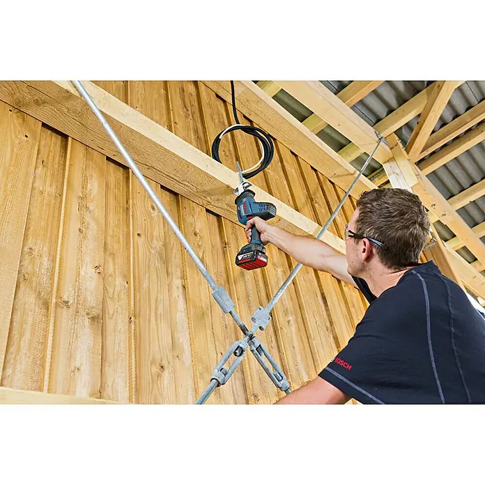 Bosch Professional AMPShare 18V Akku-Säbelsäge GSA 18 V-LI C L-Boxx - 18 V, Ohne Akku, 3.050 /min, Koffer - Der Mann benutzt eine Bosch Akku-Säbelsäge, um auf einer Baustelle zu arbeiten, ideal für präzise Schnitte und flexible Anwendungen.