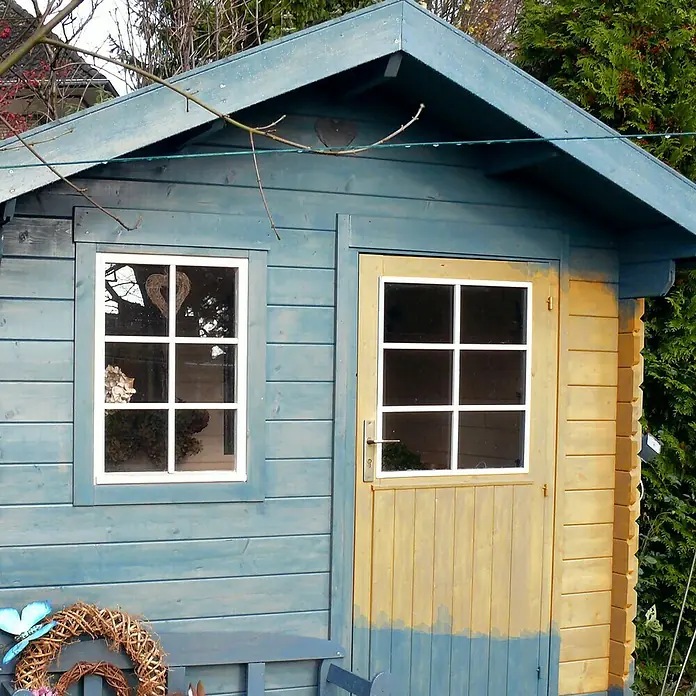 Fartools Bürstenwalze Kupferdrahtbürste - Durchmesser: 8 cm, Geeignet für: Holz - Nahaufnahme eines blauen Gartenhauses mit einem weißen Fenster und einer gelben Tür. Ein charmanter und funktionaler Akzent für jeden Garten.