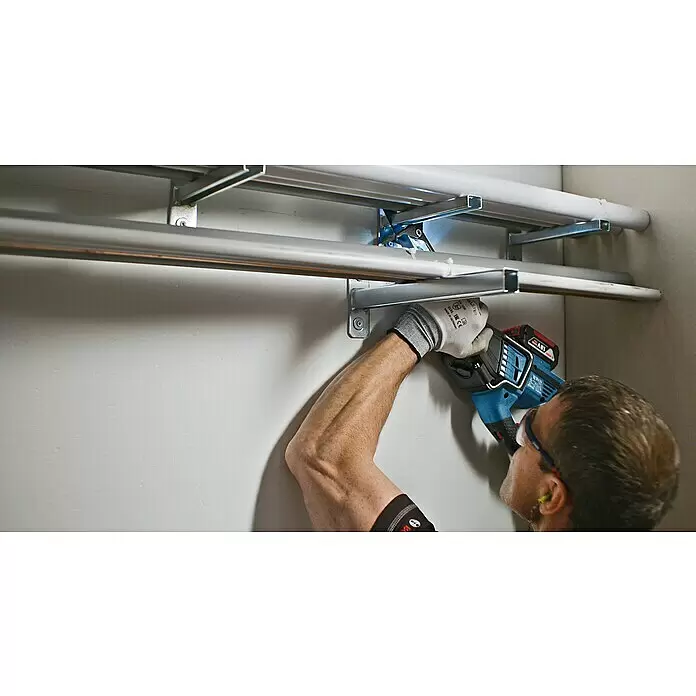 Bosch Professional AMPShare 18V Sierra de sable de batería GSA 18V-32 - 18 V, Sin batería, 0 /min - 2.500 /min, Maleta - Hombre usando una sierra de sable azul a batería para cortar tubos metálicos en la pared.