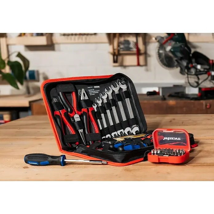 Wisent Werkzeugkoffer Servicebag - L x B x H: 340 x 230 x 74 mm, 56 -tlg. - Werkzeugsatz mit Schraubenzieher und verschiedenen Werkzeugen in einer roten und schwarzen Tasche auf einem Holztisch.
