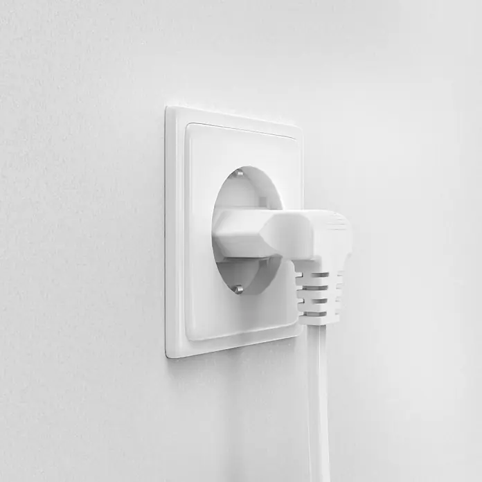 Hama Netzkabel 90° gewinkelt Doppelnut C7 - Weiß, Länge: 5 m, Eurostecker, 2,5 A - Nahaufnahme einer weißen Steckdose mit eingestecktem Stecker an einer weißen Wand.