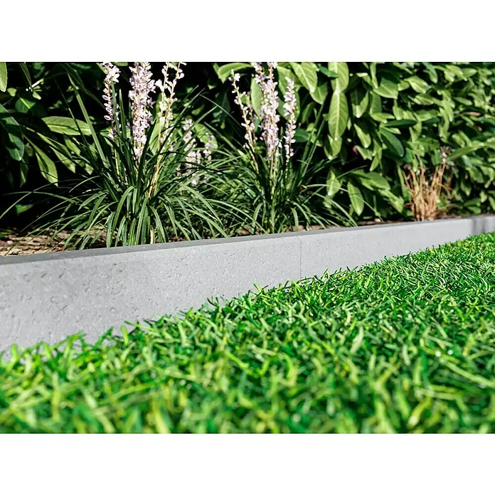 EHL Rasenkante C - 100 x 6 x 25 cm, Grau, Beton - Nahaufnahme einer grauen Rasenkante, die einen gepflegten Gartenbereich mit Blumen und üppigem Grün abgrenzt und für Struktur sorgt.
