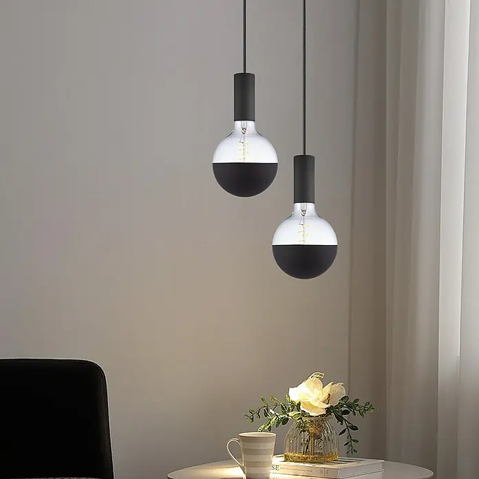 Home Sweet Home LED-Lampe Filament Classic Vintage Globe-Form - E27, Dimmbar, Neutralweiß, 280 lm, 4 W - Zwei stilvolle Pendelleuchten mit halbschwarzen, runden Lampenschirmen über einem Tisch mit Blumenvase und Tasse.