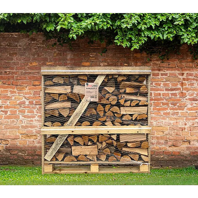 Fireland Kaminholz Raummeter - Laubholz, Länge Holzscheit: 25 cm - 33 cm - Ein Palettenregal gefüllt mit Kaminholz, ordentlich gestapelt und mit einem Etikett versehen. Der Holzhaufen steht vor einer Backsteinmauer.