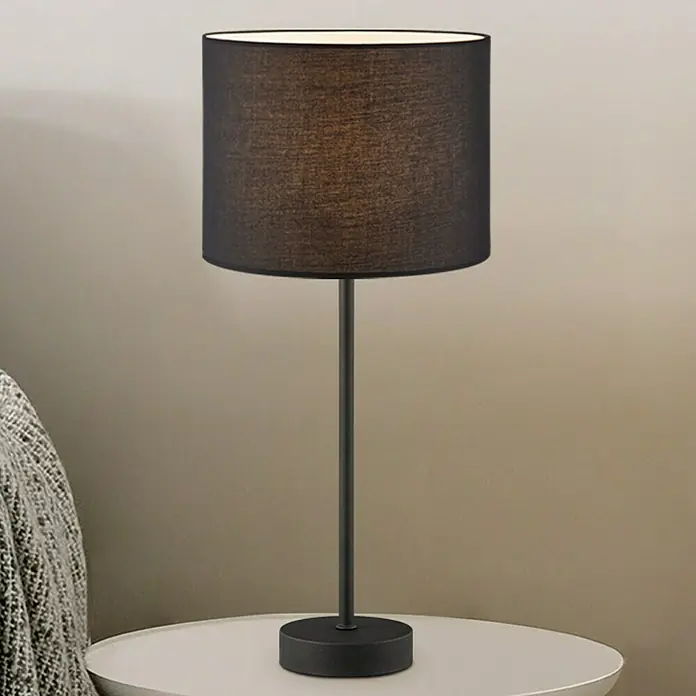 Home Sweet Home Lampenfuß Single 37 - 10 W, Höhe: 36,5 cm, Schwarz, Edelstahl, E27 - Nahaufnahme einer modernen Tischleuchte mit schwarzem Lampenschirm und schlankem Ständer auf einem weißen Tisch.