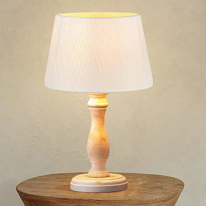 Home Sweet Home Lampenschirm - L x B x H: 20 x 15 x 13 cm, Weiß, E27 - Nahaufnahme einer eleganten Tischlampe mit einem cremefarbenen Lampenschirm und einem verzierten Holzfuß auf einem rustikalen Holztisch.