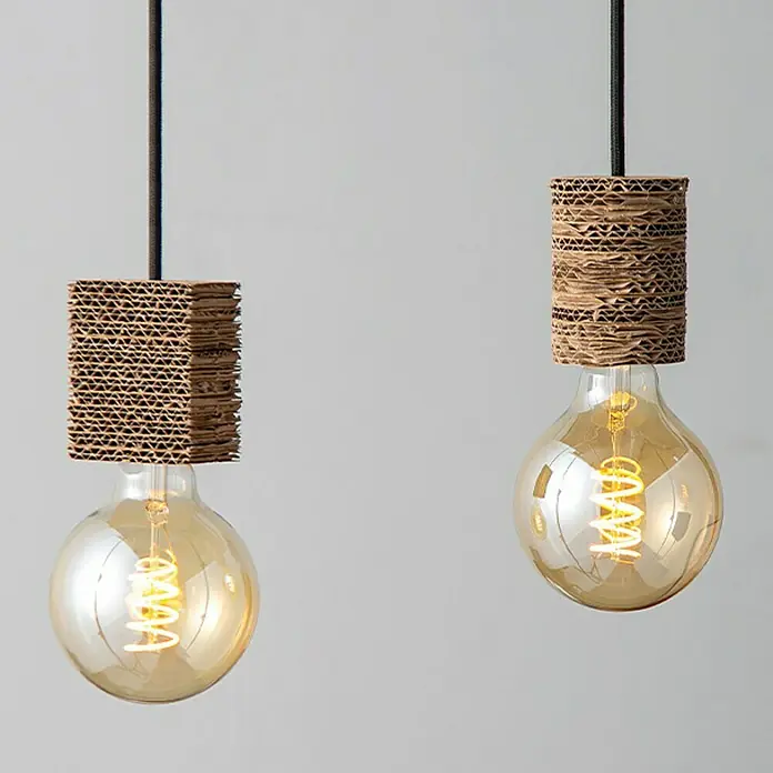 Home Sweet Home Lampenfassung - E27, Braun, Papier, Rund - Zwei moderne Pendelleuchten mit spiralförmigen Glühbirnen und Lampenschirmen aus recycelter Pappe vor einem neutralen Hintergrund.