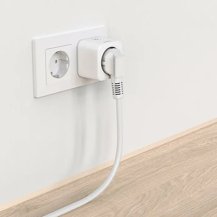 Hama Smart-Steckdose WLAN Matter - Innen, Weiß, 3.680 W - Eine Nahaufnahme einer Steckdose mit einem intelligenten Stecker und einem weißen Kabel, das mit einer Wand verbunden ist.