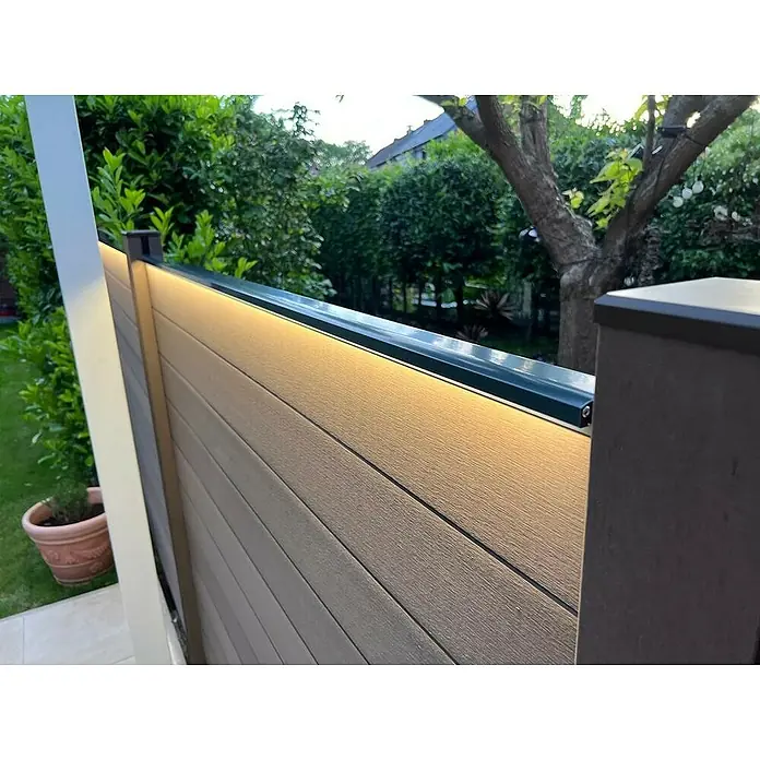 LyghtUp Zaunbeleuchtung Starter-Set - Länge: 173,3 cm, Anthrazit, Passend für: WPC- und Aluminium-Steckzäune, 3 -tlg. - Nahaufnahme eines modernen Gartenzauns mit integrierter Beleuchtung, die ein warmes Licht auf die horizontalen Paneele wirft.