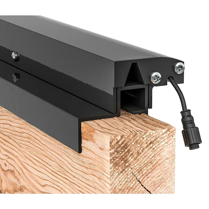 LyghtUp Zaunbeleuchtung Starter-Set - Länge: 173,3 cm, Anthrazit, Passend für: Holzzäune mit 40 mm Stärke, 8 -tlg. - Nahaufnahme einer schwarzen LED-Terrassenbeleuchtung, die an einem Holzpfosten befestigt ist und modernes Design und Funktionalität vereint.