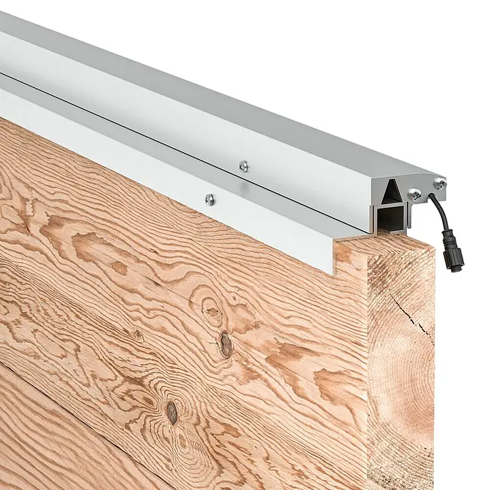 LyghtUp Zaunbeleuchtung Starter-Set - Länge: 173,3 cm, Silber, Passend für: Holzzäune mit 40 mm Stärke, 4 -tlg. - Detailaufnahme einer LED-Leuchte in einem Aluminiumprofil, montiert an einem Holzbalken.