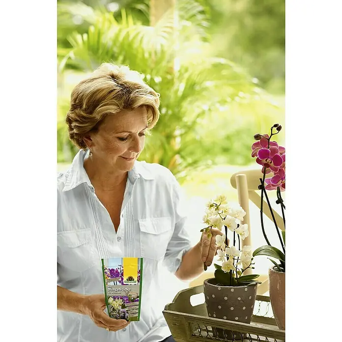 Neudorff Azet Blühpflanzen-Düngestäbchen Orchideen I - 40 Stk. - Frau gießt ihre Orchideen mit Neudorff Düngesack Blumendünger für Orchideen und Grünpflanzen.