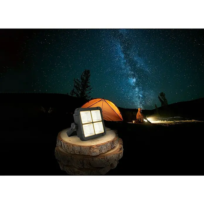 Globo Solar-LED-Strahler16 W, 1.000 lm, Lichtfarbe: Neutralweiß - Camping-Szene mit einem hellen LED-Flutlicht auf einem Holzschemel im Vordergrund, ein Zelt und Sternenhimmel im Hintergrund.
