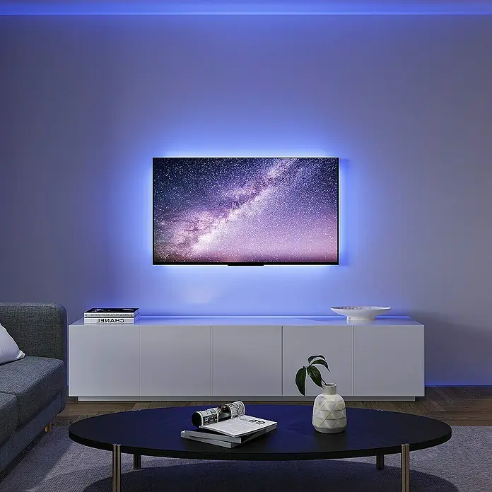 Trio Lighting Tira LED inteligente Screen - Largo: 3 m, RGBW, 3,5 W, 230 V - Un salón moderno con un televisor con luces LED, creando un ambiente relajante. El diseño elegante se combina con la tecnología.