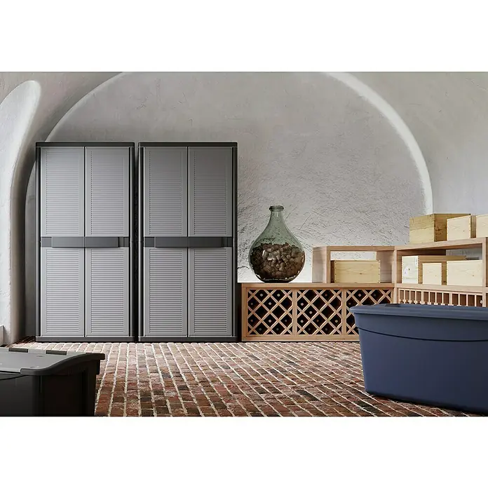 Terry Kunststoff-Mehrzweckschrank Jumbo 3900 QBlack - L x B x H: 53,7 x 89,7 x 180 cm - Lagerraum mit zwei grauen Schränken, einem Weinregal, Holzkisten und einer großen Glasvase mit Korken.