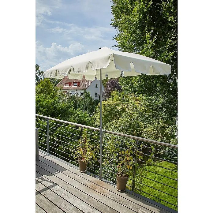 Sunfun Balkonklammer - Grau, Für Rohrdurchmesser: 25 mm - 32 mm - Dieser quadratische Sonnenschirm mit gewelltem Rand bietet optimalen Sonnenschutz auf einer Holzterrasse mit üppigem Grün im Hintergrund.