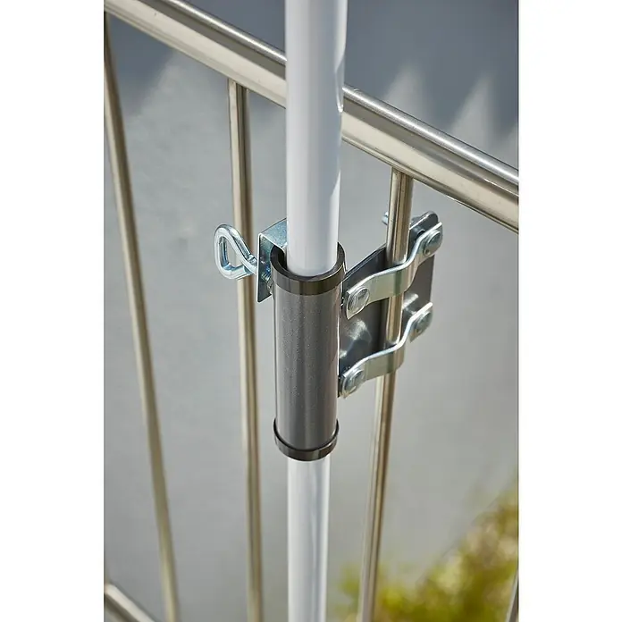 Sunfun GeländerhalterungStahl, Für Rohrdurchmesser: 22 mm - 25 mm - Nahaufnahme einer Sonnenschirmhalterung, die an einem Geländer befestigt ist und einen weißen Sonnenschirmmast hält.
