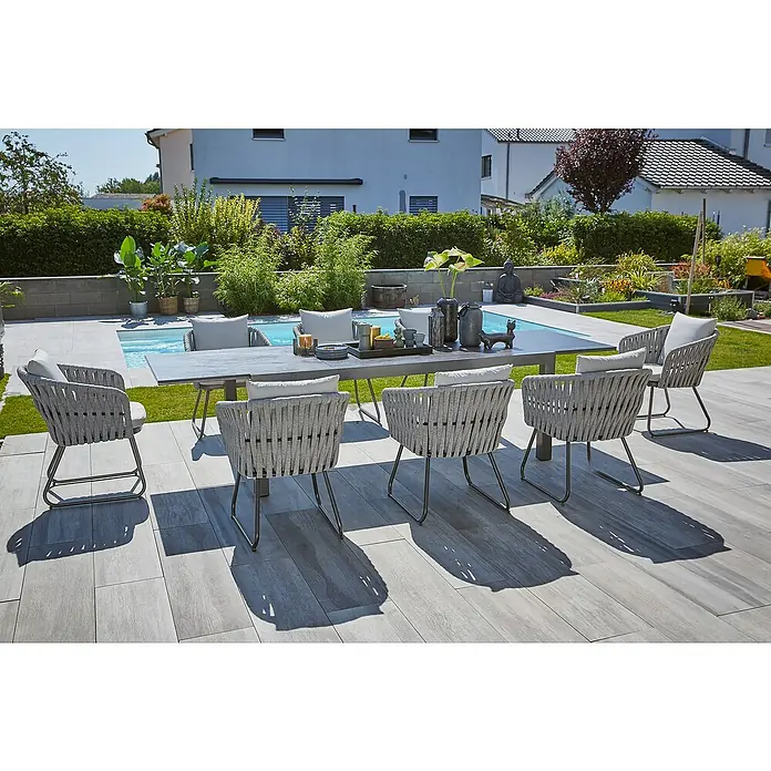 Sunfun Maja Gartensessel - Seilgeflecht, Grau-Beige, B x T x H: 64 x 65 x 77 cm - Outdoor-Esstisch mit grauen Seilstühlen um einen Tisch herum, der auf einer Terrasse am Pool steht.