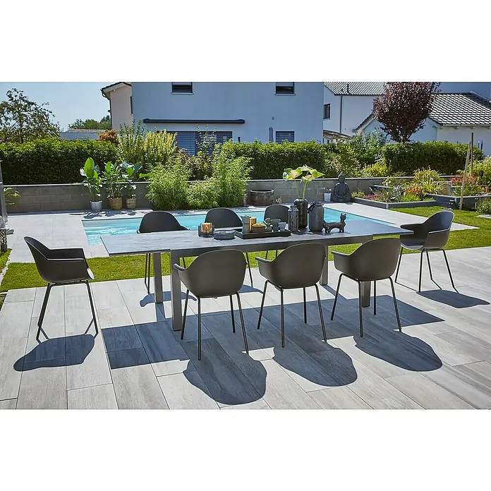 Sunfun Gartenmöbel-Set Maja Stone/My - 9 -tlg., Sintered Stone/Aluminium/Stahl/Kunststoff, Tischplatte ausziehbar, Anthrazit/Schwarz - Eine moderne Gartenszene mit einem Esstisch und Stühlen, die zum Entspannen im Freien einladen. Elegantes Design trifft auf natürliche Umgebung.
