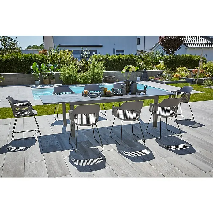 Gartensessel Annika - Black/Dark Grey, B x T x H: 57 x 60 x 82 cm - Grauer Outdoor-Esstisch mit passenden Stühlen auf einer Terrasse neben einem Pool, ideal für Mahlzeiten im Freien und Entspannung.