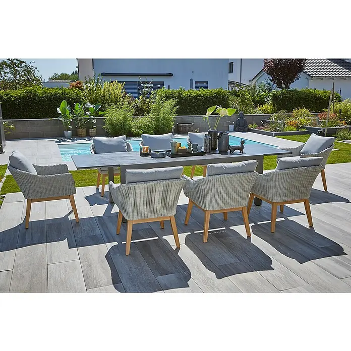 Sunfun Gartenmöbel-Set Maja Stone/Paula XL - 9 -tlg., Sintered Stone/Aluminium/Akazie/Kunststoffgeflecht, Tischplatte ausziehbar, Anthrazit/Hellgrau - Ein grauer Gartentisch mit sechs Sesseln aus Rattan mit grauen Auflagen, perfekt für Mahlzeiten im Freien und zum Entspannen.