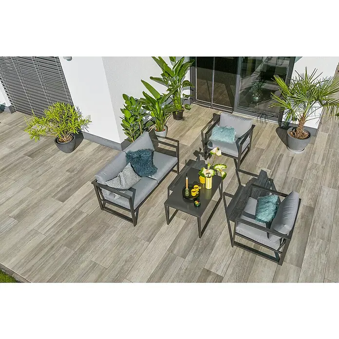 Sunfun Maja Slim Loungemöbel-Set - 4 -tlg., Aluminium/Polyesterfaser, Anthrazit/Grau - Eine moderne Terrassengarnitur mit grauen Kissen und stilvollen Dekorationen auf einem gefliesten Außenbereich.