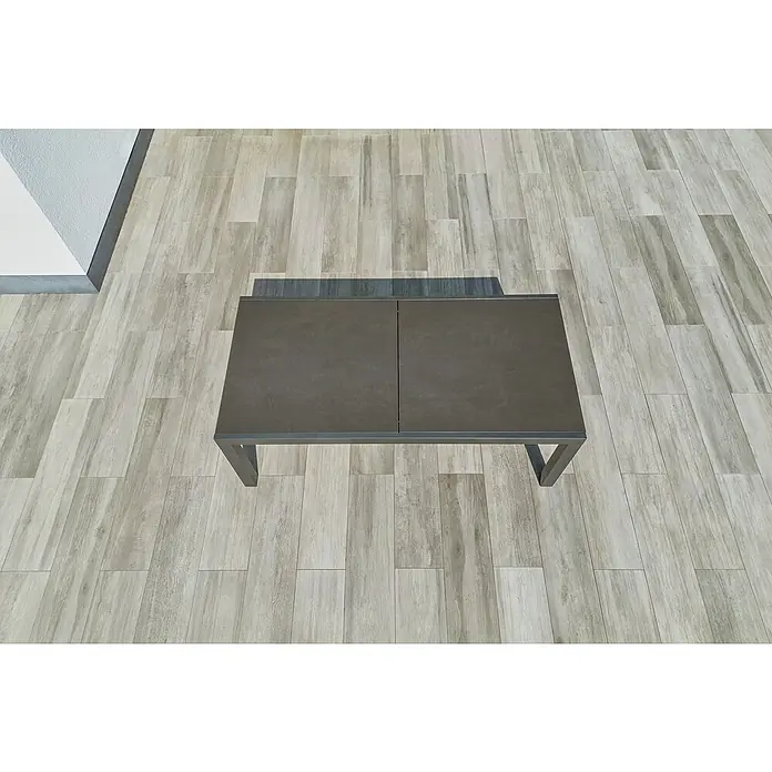 Sunfun Maja Gartentisch Stone - L x B x H: 300 x 100 x 74 cm, Aluminium, Sintered Stone, Ausziehbar, Night-Grey - Blick von oben auf einen rechteckigen Couchtisch mit Metallgestell, der auf einem Holzboden steht.