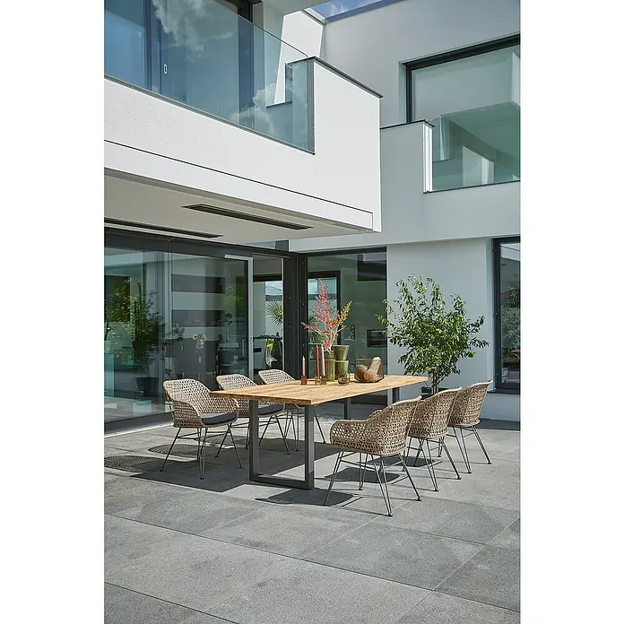 Sunfun Maja Gartenmöbel-Set - 8 -tlg., Baumkante/U-Gestell, Teak/Edelstahl/Stahl/PE-Geflecht, Teak/Grau/Braun - Moderne Gartensitzgruppe mit einem Holztisch und sechs Rattansesseln auf einer grauen Steinterrasse, ideal für stilvolle Außenbereiche.