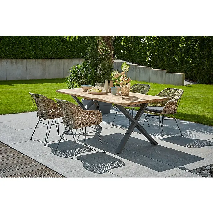 Sunfun Maja Gartenmöbel-Set - 6 -tlg., Baumkante/X-Gestell, Teak/Edelstahl/Stahl/PE-Geflecht, Teak/Grau/Braun - Ein Gartentisch-Set mit einem Holztisch und vier Korbstühlen auf einer Terrasse, umgeben von Grün.