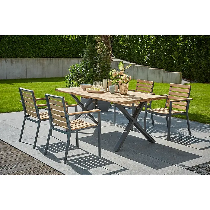 Sunfun Garten-Tischplatte180 x 90 cm, Teakholz, Baumkante - Nahaufnahme eines Gartentisches mit Stühlen, der mit Geschirr und Blumen dekoriert ist. Perfekt für Mahlzeiten im Freien!