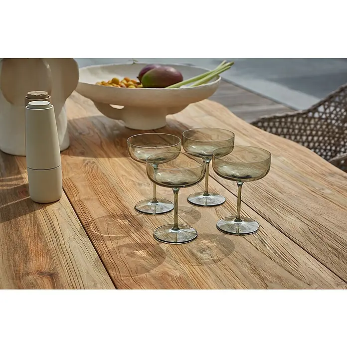 Sunfun Garten-Tischplatte220 x 100 cm, Teakholz, Baumkante - Elegante graue Cocktailgläser auf einem Holztisch, neben einer stilvollen Vase und einer Schale mit Früchten.