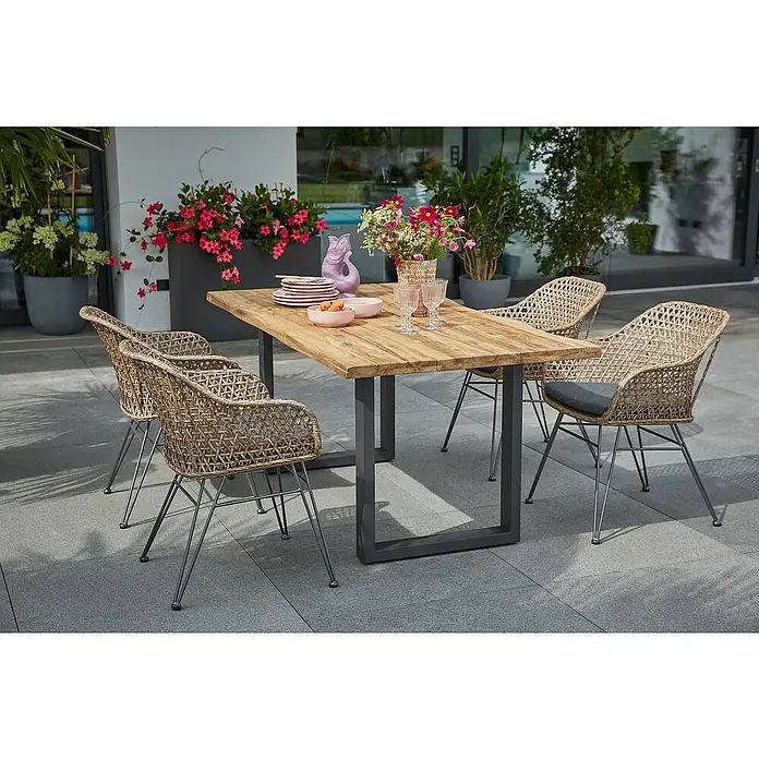 Sunfun Maja GartensesselBraun-Grau, PE-Geflecht - Ein Gartentisch mit Holzplatte und vier Rattanstühlen mit Metallbeinen. Der Tisch ist mit Geschirr und Blumen dekoriert.