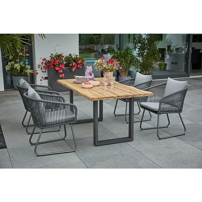 Sunfun Maja Gartenmöbel-Set - 6 -tlg., Baumkante/U-Gestell, Teak/Edelstahl/Kunststofffaser-Schnüre, Teak/Grau - Eine moderne Gartengarnitur mit einem Holztisch und vier Stühlen mit grauen Polstern auf einer Terrasse.