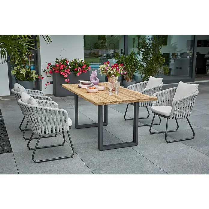 Sunfun Maja Gartenmöbel-Set - 6 -tlg., Teak/Edelstahl/Seilgeflecht, Teak/Grau/Beige, Baumkante/U-Gestell - Ein Gartentisch mit Holzplatte und vier grauen Seilstühlen mit Kissen steht auf einer Terrasse. Perfekt für Mahlzeiten im Freien!