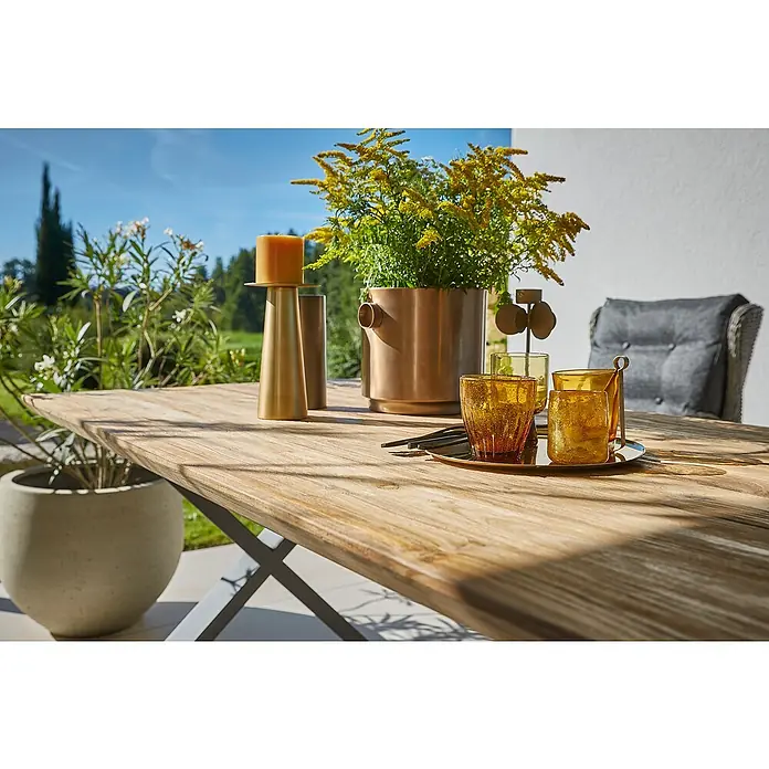Sunfun Garten-Tischplatte - L x B: 220 x 100 cm, Teak, Schweizer Kante - Eine Nahaufnahme eines Tisches im Freien mit Kerzenhalter, Blumenvase und Trinkgläsern.