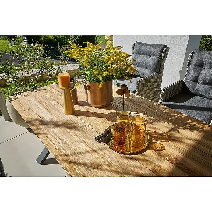 Sunfun Garten-Tischplatte - L x B: 180 x 90 cm, Teak, Schweizer Kante - Nahaufnahme eines dekorierten Holztisches mit goldenen Akzenten, Kerzen und Gläsern.