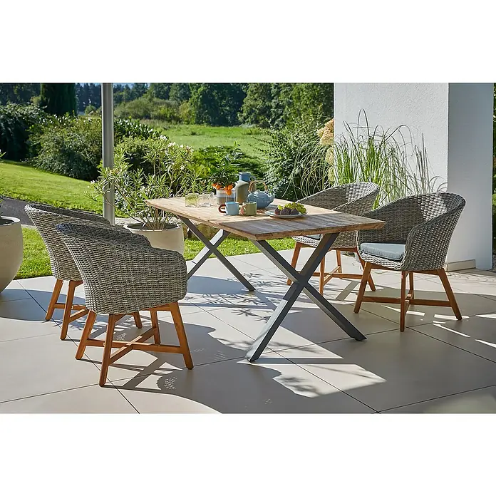 Sunfun Pauline Gartenmöbel-Set - 6 -tlg., Schweizer-Kante/X-Gestell, Teak/Edelstahl/Akazie, Teak/Grau/Braun - Bild eines Gartentisches mit Stühlen. Das Set beinhaltet einen Tisch mit Holzplatte und Metallgestell sowie vier Korbstühle mit Kissen.