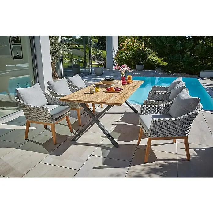 Sunfun Gartentisch - L x B x H: 220 x 100 x 75 cm, Edelstahl, Teak, Natur/Anthrazit, Schweizer Kante/X-Fuß - Ein einladender Essbereich im Freien mit einem Holztisch und sechs Korbstühlen mit grauen Kissen. Ideal für Mahlzeiten im Freien.