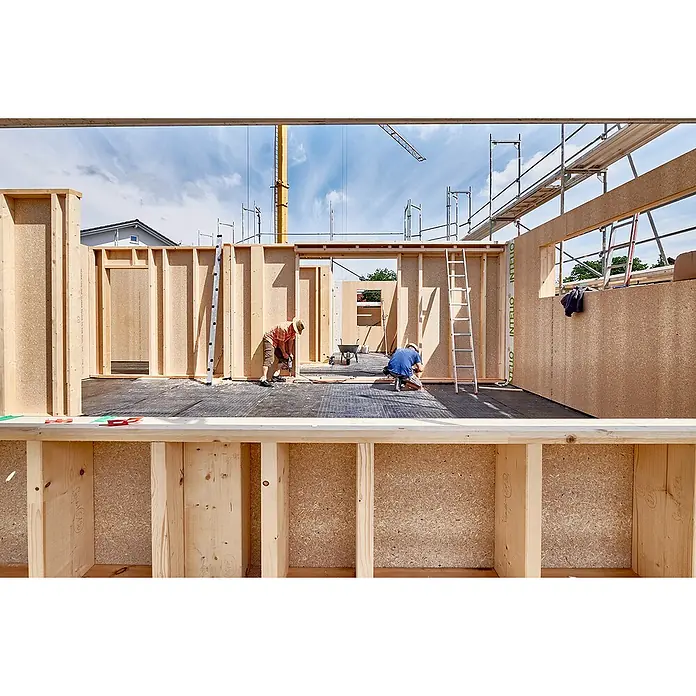 elka ESB-Platte Plus - Im Bau befindliches Holzhaus mit zwei Bauarbeitern, die an den Wänden arbeiten. Im Vordergrund ein Holzbalken.