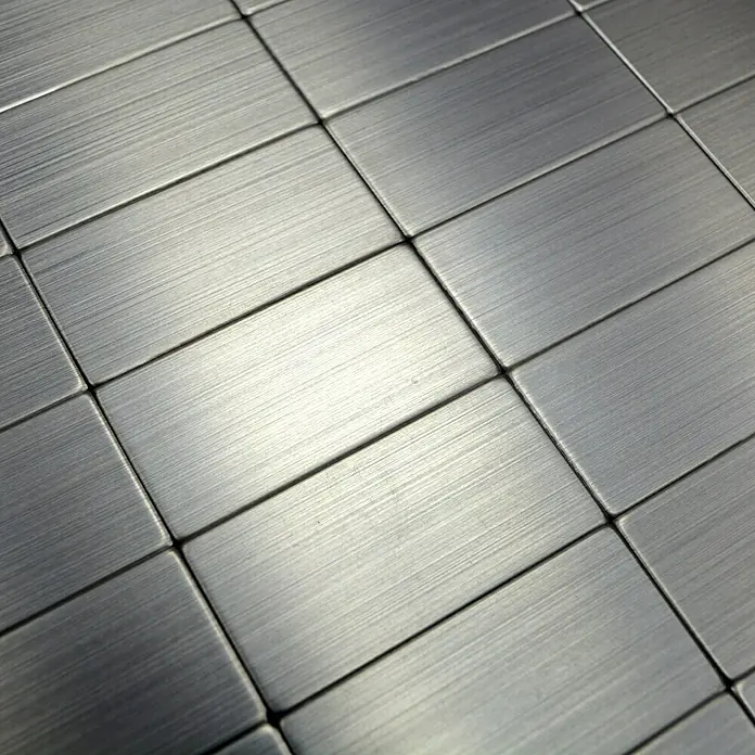Selbstklebemosaik SAM 4MM50 - 30,5 x 30,5 cm, Silber, Glänzend - Das Bild zeigt eine Nahaufnahme von rechteckigen, metallischen Fliesen mit einer gebürsteten Oberfläche, die ein modernes Design aufweisen.